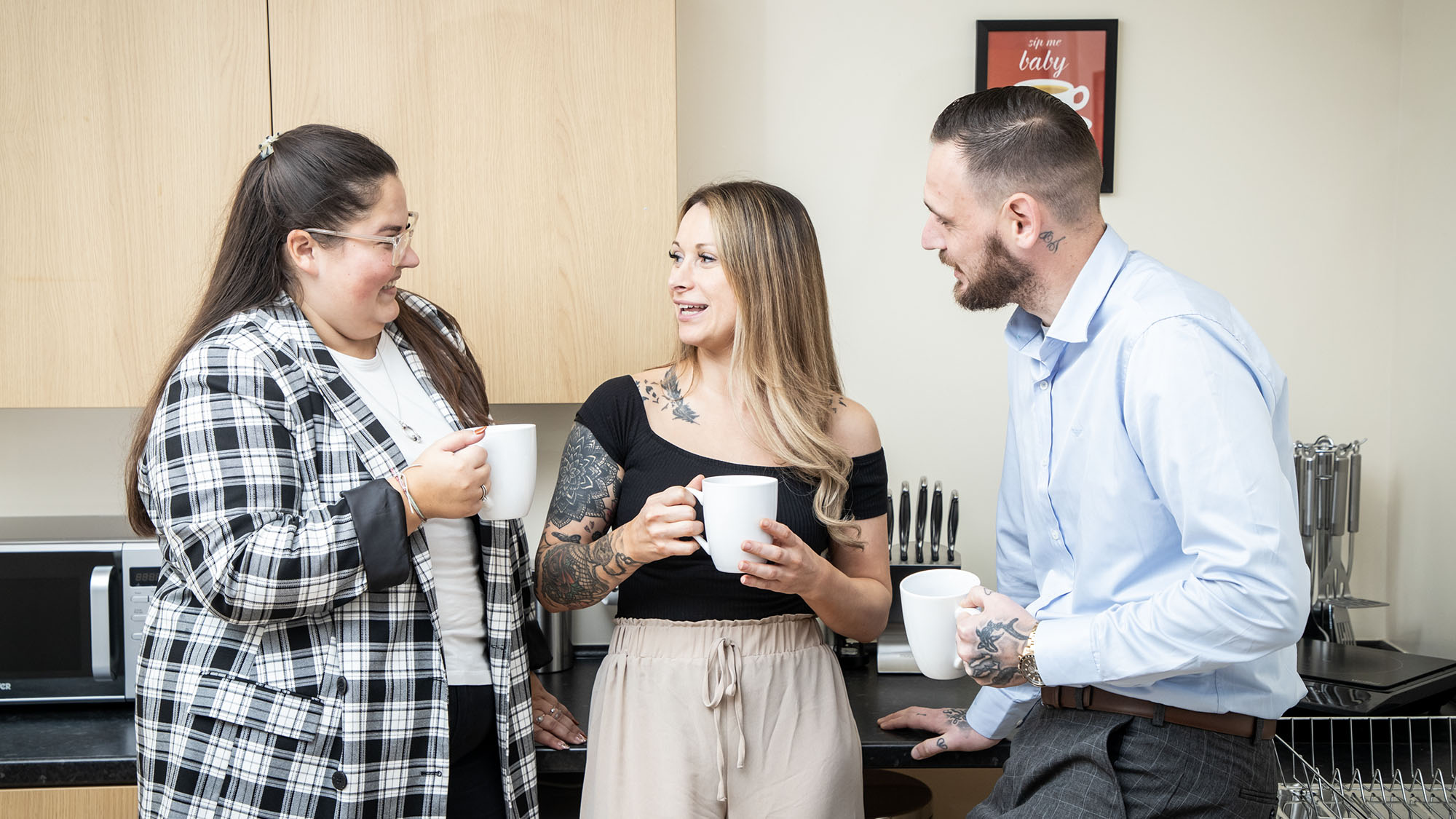 Jiggle colleagues in conversation in a kitchen.