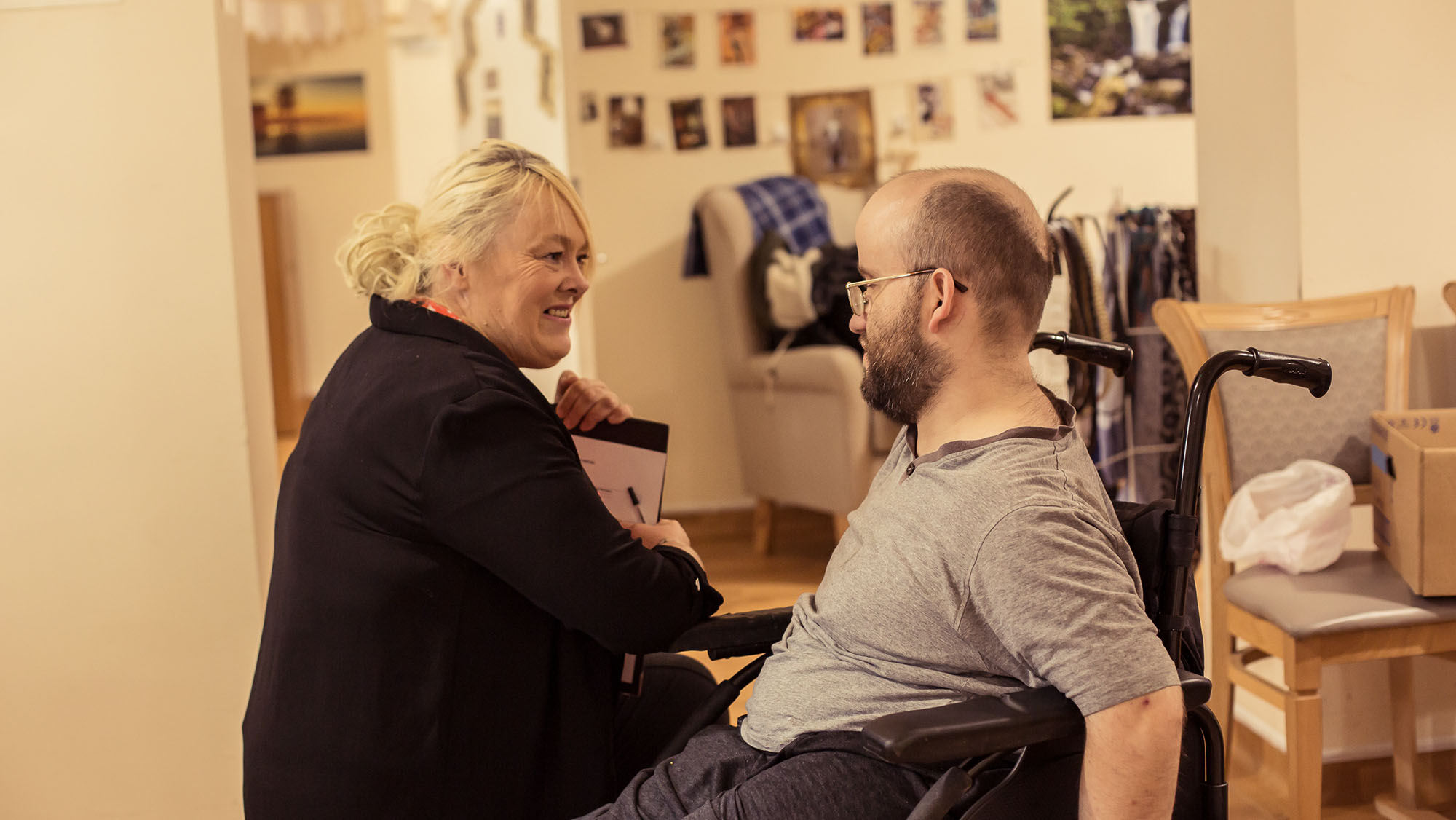 Carer talking to a patient in a wheelchair.